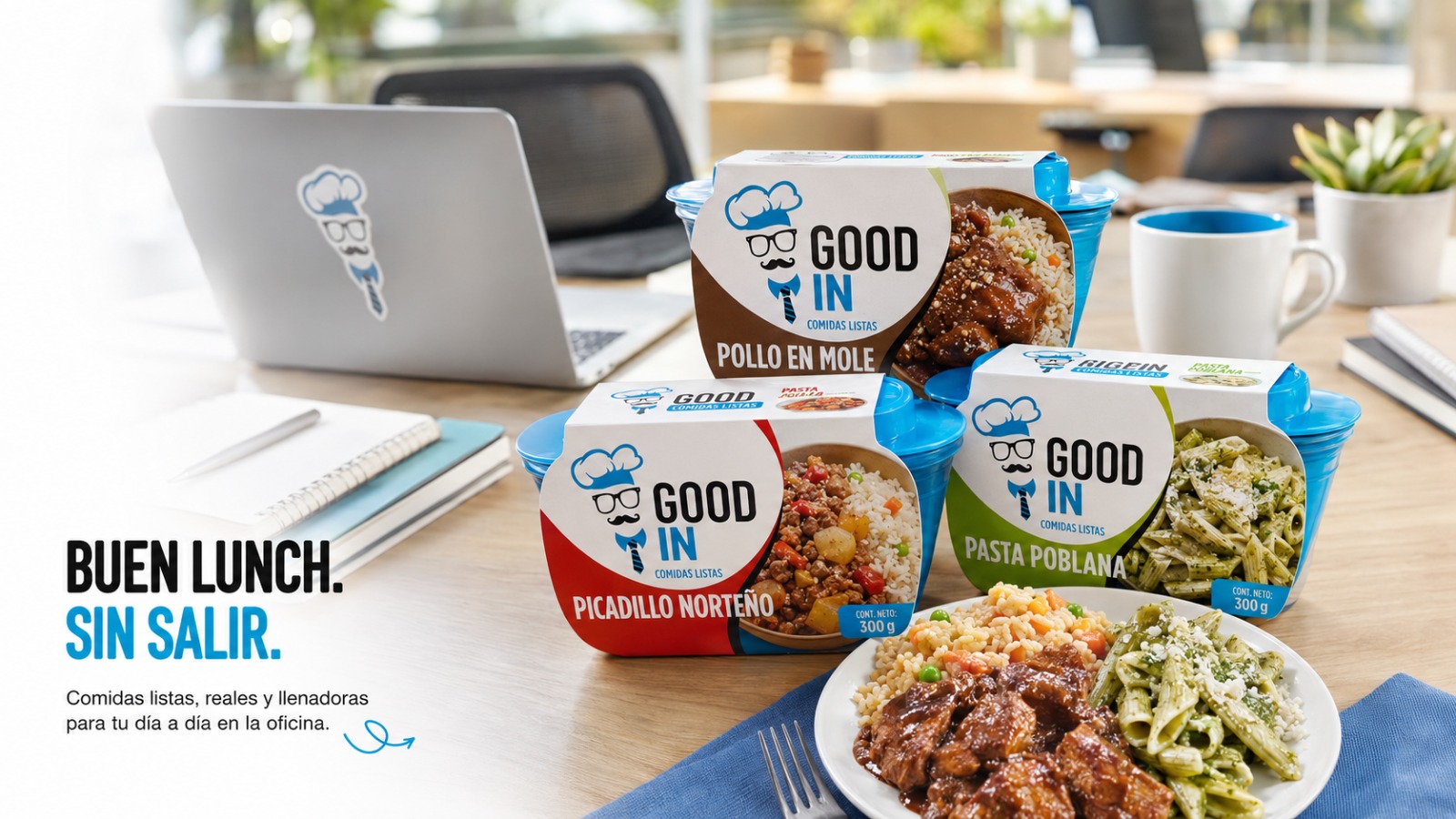 Comidas listas GOODin sobre un escritorio de oficina: pollo en mole, picadillo norteño y pasta poblana